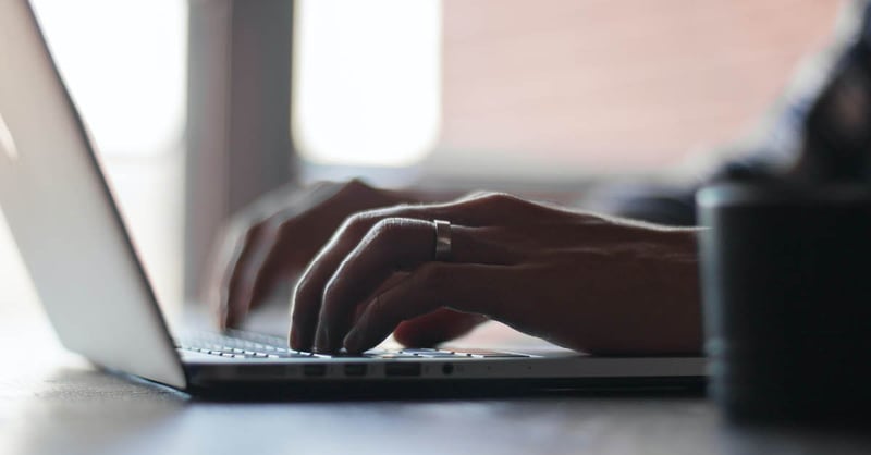 Closeup of hands typing on laptop