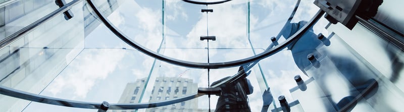 Mirrored windows on an urban building reflecting the skyline.